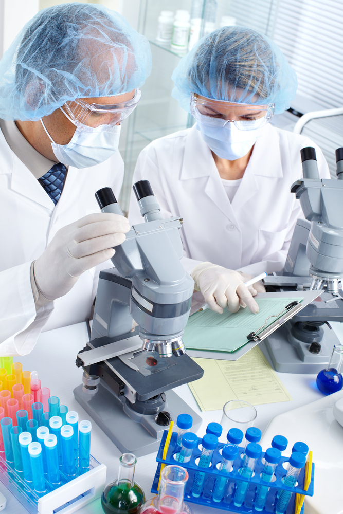 Medical Researchers studying with microscope and clipboard